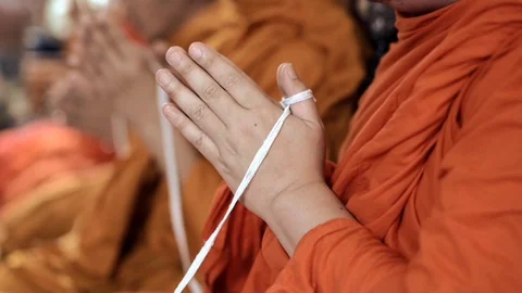Holy thread holding by buddhist monk while praying in religious ceremony Stock Footage 111122074