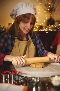Home Baker In Chef Hat Rolling Dough On Floured Counter Amid Festive Lights Stock Photos