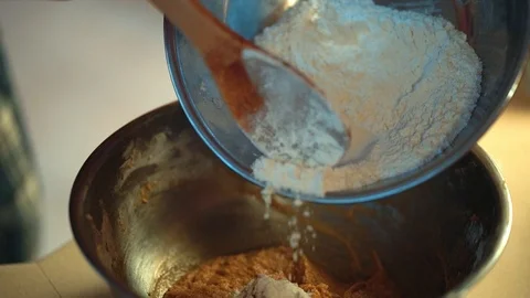 Home baking - carefully placing flour into the cookie dough mix 動画素材 94038549