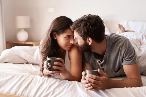 Home bedroom, coffee and couple bonding, relax and enjoy morning latte, espresso Stock Photos