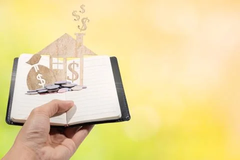 Home a book saving power saving money On a wooden floor, background, light, b Stock Photos
