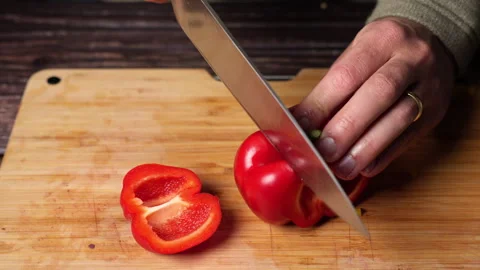 Home chef cutting red bell pepper on a wooden cutting board. Stock Footage 301443610