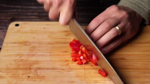 Home chef cutting red bell pepper on a wooden cutting board. Stock Footage 301444225