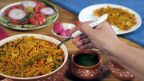 Home chef's hand serving a spoonful of freshly made vegetable fried rice Stock-Footage 157415246