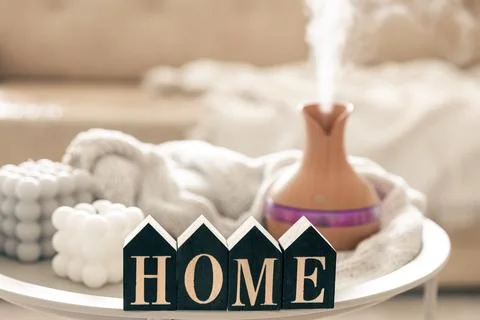 Home composition with aroma diffuser lamp and candle on a blurred background. Stock Photos