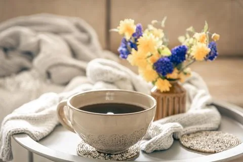 Home composition with a cup of tea and flowers on a blurred background. Stock Photos