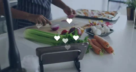 Home cook chopping onion for dinner at kitchen counter, causing hearts Stock Footage 321377810