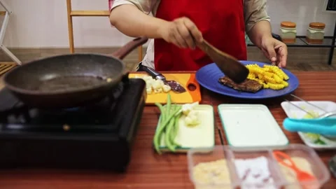 Home cook plating cooked beef steak beside crinkle-cut fries on blue plate Stock Footage 345379926