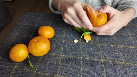 Home cook skillfully separates tangerine into juicy sections Stock Footage 323358715