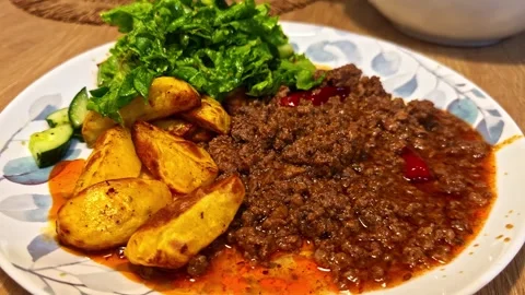 Home-Cooked Ground Beef Dinner Served with Roasted Potato Wedges and Fresh Stock Footage 341544646