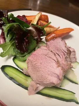 Home Cooked Meal I Medium Rare Pork Roast - Cucumbers, Carrots, and Salad Stock Photos