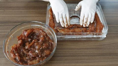 Home cooking Chicken slices while dehydrating making jerky in Dehydrator. Stock Photos