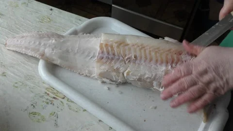 Home cooking process.  The cook is cleaning the cod fish.  Healthy food concept 動画素材 136638385