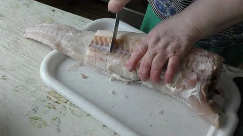 Home cooking process.  The cook is cleaning the cod fish.  Healthy food concept Stockbeeldmateriaal 136638404