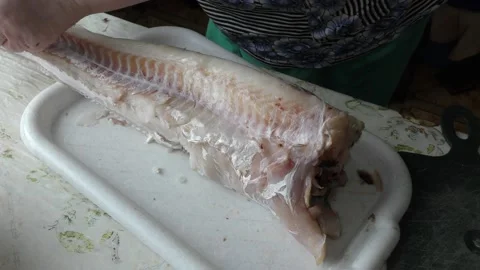 Home cooking process.  The cook is cleaning the cod fish.  Healthy food concept Vídeo Stock 136638560