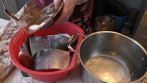 Home cooking process.  The cook is salting the fish with trout. Video stock 155227669