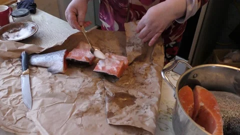 Home cooking process.  The cook is salting the fish with trout. Video stock 155228432