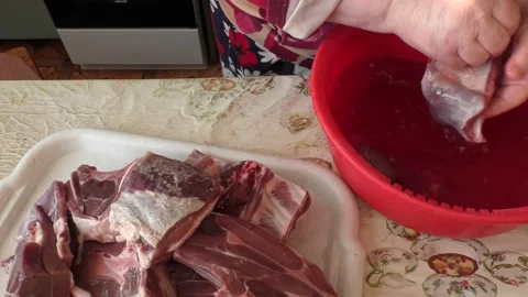 Home cooking process.  The cook washes the deer meat in water. Video stock 155497296