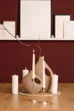 Home decor with candle holders on table near burgundy wall in dining room Stock Photos