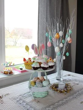Home decor at Easter. Easter eggs hang on the branches of a tree standing in 스톡 사진