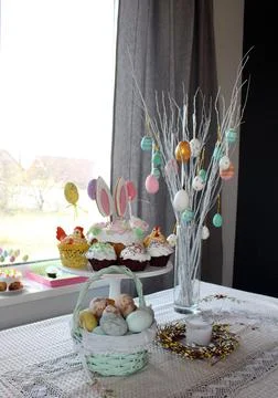 Home decor at Easter. Easter eggs hang on the branches of a tree standing in Stock Photos