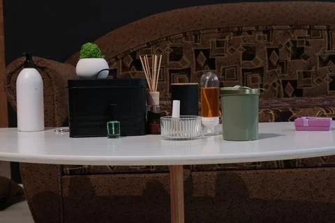 Home decor items including a diffuser, candle, and nail polish on a table Stock Photos