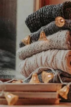 Home decor, sweaters, a stack of books and light bulbs, cozy winter interior  Foto stock