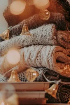 Home decor, sweaters, a stack of books and light bulbs, cozy winter interior  Foto stock