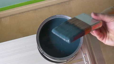 Home decorating, painter dipping paintbrush in modern blue paint pot Stock Footage 147539591