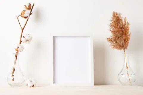Home decoration with white mock up frame on table. Artwork showcase. Scandina Stock Photos