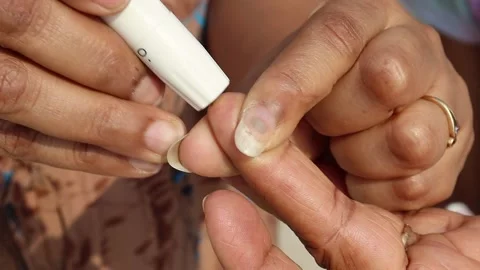 At home doing a finger prick test for blood sugar. Drawing blood Stock Footage 238847388