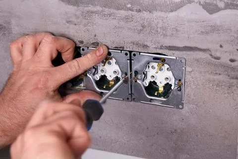 Home electrical repair in progress with tools and wiring on the wall Stock Photos