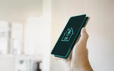 Home electrical system active icon on smartphone screen holding in a hand Stock Photos