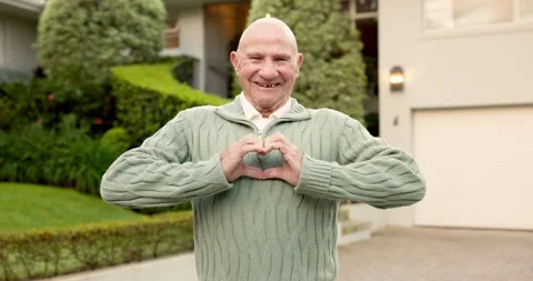 Home, face and old man in front yard with heart hands, property purchase and Stock Footage 345627296