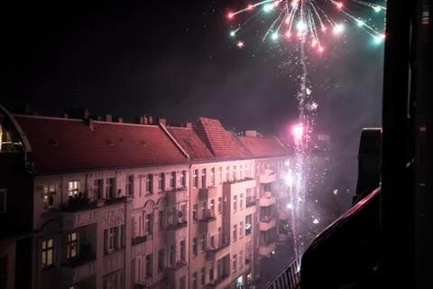 Home fireworks explode from balcony high in Berlin streets new year Foto stock