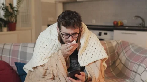 In Home Flu Conversation A Young Man Talking on Smartphone, Experiencing Cold Stock Footage 281596565