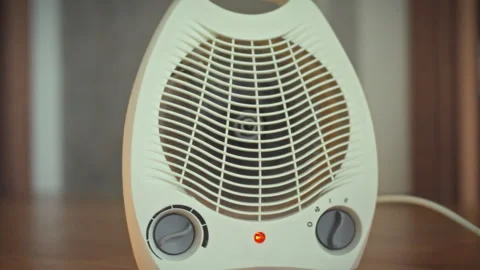 A home heater is in operation emitting warmth into the room through its fan- Stock Footage 331313551