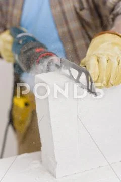 Home improvement - handyman cut brick with saw Stock Photos