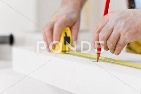 Home improvement - handyman measure porous brick Stock Photos