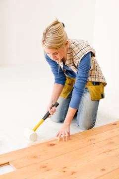 Home improvement - handywoman installing wooden floor Stock Photos