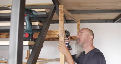 Home improvement, man assembling wood shelf at home drilling pilot holes Stock Footage 321880262