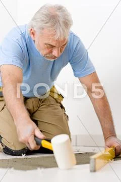 Home improvement, renovation - handyman laying tile Stock Photos