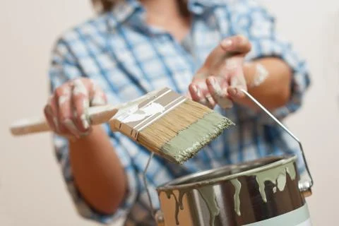 Home improvement: woman holding paint brush and can Stock Photos
