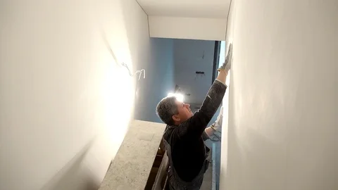 Home improvement worker with gloves working with sander for smooth wall surface Stock Footage 106650595