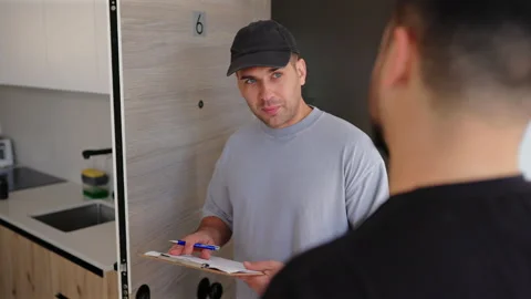 Home inspection and maintenance worker takes notes on clipboard at apartment. Vídeo Stock 342947707
