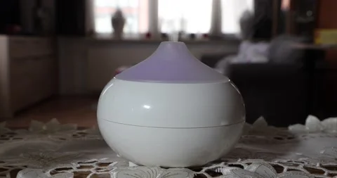 Home interior with an aroma oil diffuser humidifier exhaling fragrance mist Stock Footage 211171883