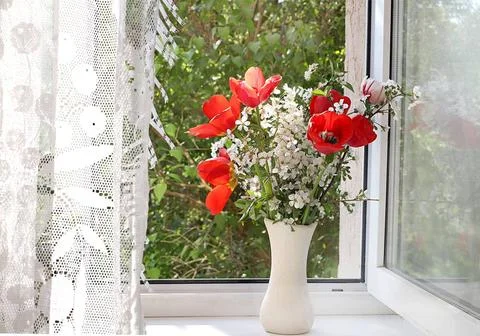 Home interior with decor elements, beautiful spring lilac branches and tul... Stock Photos