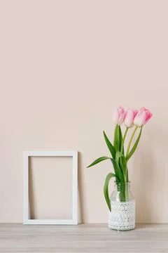 Home interior with decor elements. Mockup with a white frame and pink tulips Foto stock