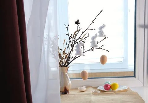 Home interior with Easter decor, with branches in a vase and painted eggs o.. Stock Photos