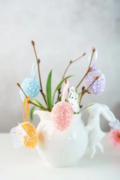 Home interior with easter decor. Vase with willow tree branches with Easter eggs Stock Photos